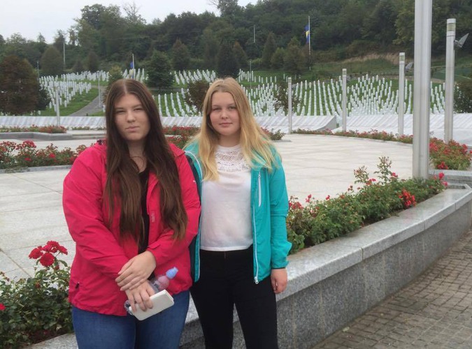 Bild på två elever som beer sig på platsen där Folkmordet i Bosien ägde rum. 