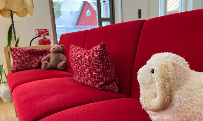 Mjukisdjur i en röd soffa.