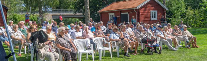Bild på inbjudna gäster som deltar i firandet av hembygsföreningens hundraårsjubileum. 