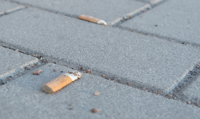 En cigarettfimp ligger på marken.
