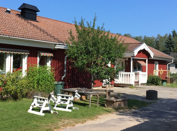 Björkhagens förskola. Ett rött envåningshus med gräsmatta och ett träd framför.